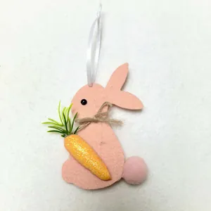 Detail of pink felt Easter bunny ornament holding a glittery carrot with white ribbon