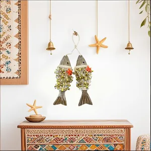 Detail of two wooden fish wall hangings with beads and starfish for garden porch decor.