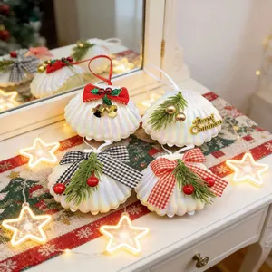 Detailansicht von vier Perlmuttschalen-Weihnachtsanhängern mit festlichen Schleifen