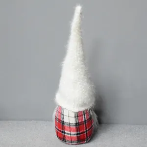 Primer plano de un gnomo navideño con gorro blanco de peluche y cuerpo de tela escocesa