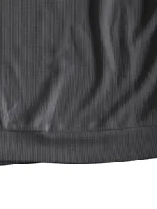 Detailansicht der dunkelgrauen Waffelstrick-Struktur eines Herren-Freizeitshirts