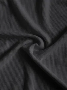 Nahaufnahme des hochwertigen, dunkelgrauen Waffelstrickstoffs für ein Herren-T-Shirt