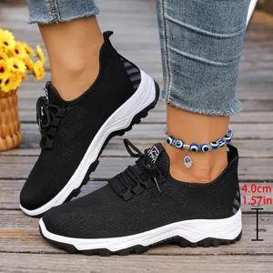 Detail of breathable black mesh sneakers with a 4cm platform sole for walking.