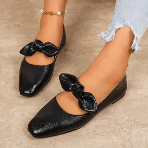 Elegant black textured Mary Jane flat shoes with large bow detail for stylish women