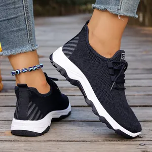 Close-up of navy breathable mesh walking shoes with thick white soles on wooden bridge