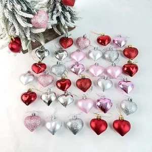 Vista dettagliata di vari ornamenti natalizi a forma di cuore opachi, lucidi e glitterati