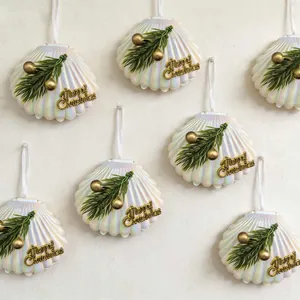Detailansicht eines irisierenden Muschel-Weihnachtsschmucks mit grüner Kiefer