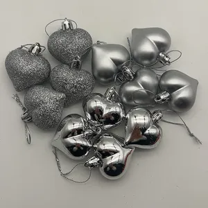 Set of 12 silver heart-shaped Christmas ornaments with glitter, matte, and shiny finishes.