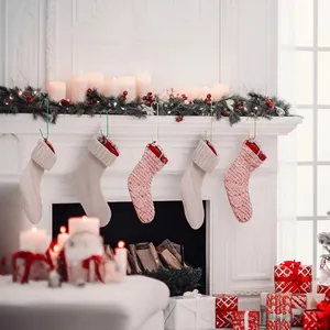 Nahaufnahme von C-förmigen Metallhaken für Weihnachtssocken an einem weißen Kamin