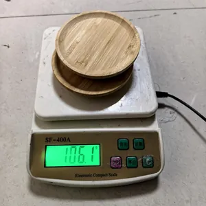 Detail view showing the weight of two round bamboo coasters on a digital scale
