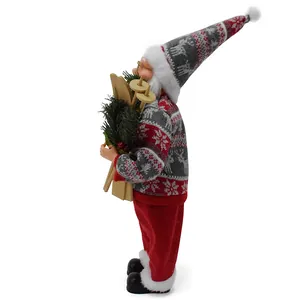 Detailed side view of Santa Claus figurine holding wooden skis and pine branches.