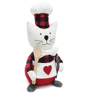 Detailed view of a handmade plush chef cat doll with red plaid hat and apron.