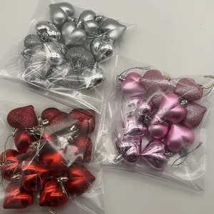 Close-up detail of three packs containing red, pink and silver heart-shaped ornaments
