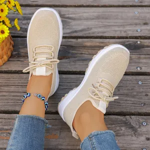 Detailed close-up view of lightweight beige mesh walking shoes with soft soles on model