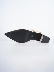 Close-up view of the black non-slip sole of cream-colored pointed toe slingback sandals.