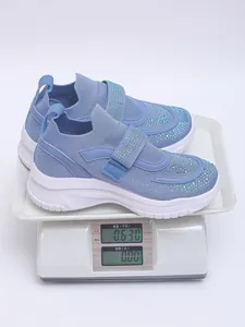 Detailweergave van blauwe sneakers met plateauzool en strasstenen op een weegschaal van 0,630 kg.