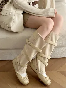 Two-wear detachable cream ballet boots with bow and buckle straps detail view
