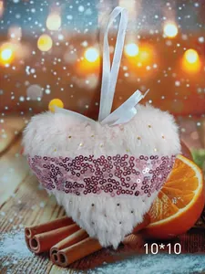 Close-up of pink plush heart ornament with sequins for Christmas tree decoration