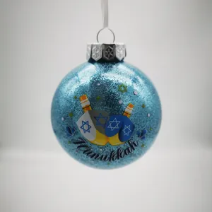 Detailansicht einer blauen Glitzer-Chanukka-Kugel mit Dreidel- und Davidstern-Design