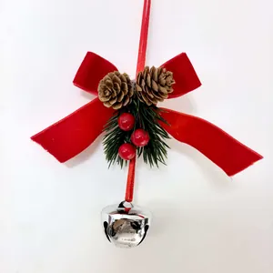 Close-up detail of Christmas bell ornament featuring red velvet bow and pine cones