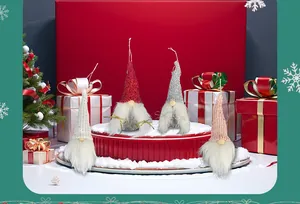 Close-up of four knitted Christmas gnomes with long beards on a red festive display