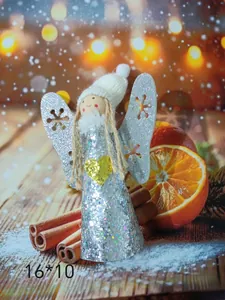 Detailed view of silver glittery Christmas angel hanging ornament with cinnamon and orange.