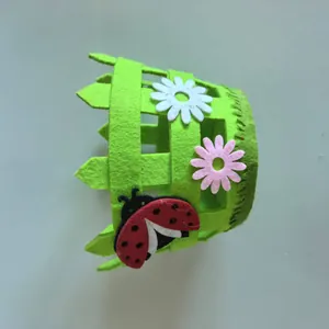 Detail view of Easter felt fence basket with ladybug and daisy applique decorations