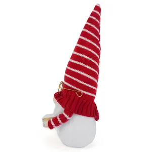 Vista laterale di uno gnomo scolastico con cappello a strisce rosse e occhiali che legge
