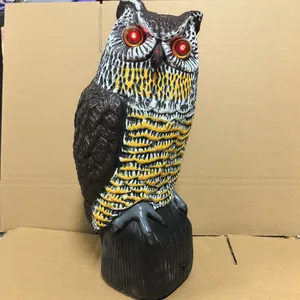 Detailed view of a solar powered garden owl scarecrow with glowing red LED eyes