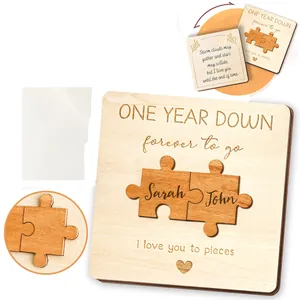 Close-up detail of a wooden anniversary puzzle card with engraved names and romantic text