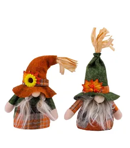 Detailed view of two Thanksgiving gnomes with sunflower and autumn leaf decorations