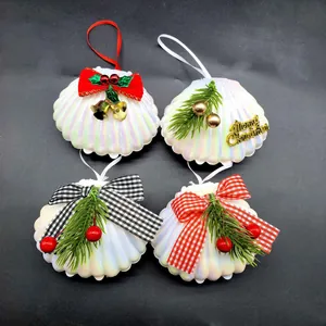 Detail von vier dekorativen Muschel-Weihnachtsanhängern mit Perlmuttglanz und Schleifen.