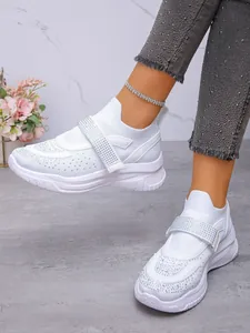 Gedetailleerd overzicht van witte platform sneakers met glimmend strass klittenband