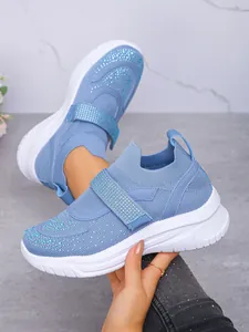 Detail van blauwe strass sneakers met dikke witte zolen en klittenbandsluiting