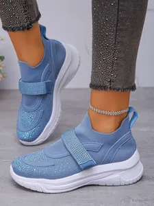 Detail van blauwe ademende sneakers met strassteentjes en handige klittenbandsluiting