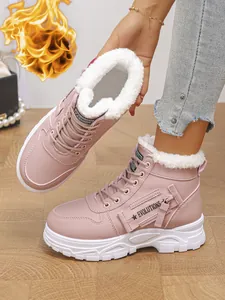 Nahaufnahme von rosa hohen Stiefeln mit warmem weißem Fleecefutter und Riemendetails.