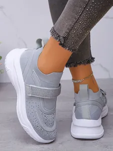 Gedetailleerde opname van ademende grijze dames sneakers met stijlvolle strass