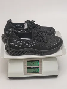 Chaussures de course en maille noire sur une balance numérique pesant 0,470 kg