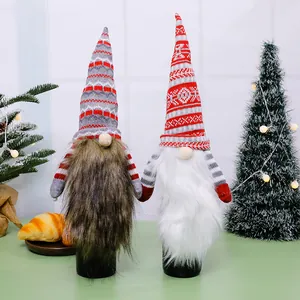 Close-up van feestelijke kerstgnome-wijnfleshoezen met gebreide mutsen en lange baarden