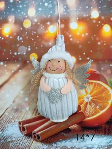 Close-up of a plush angel girl Christmas ornament with silver wings and a heart