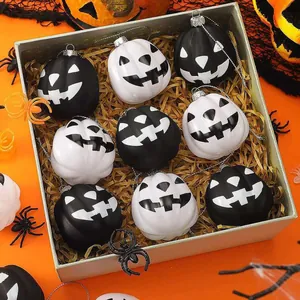 Set di nove decorazioni a forma di zucca dipinte in bianco e nero con facce di fantasmi.