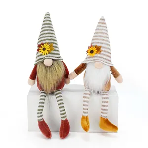 Close-up detail showing two Fall harvest faceless gnomes with striped dangling legs