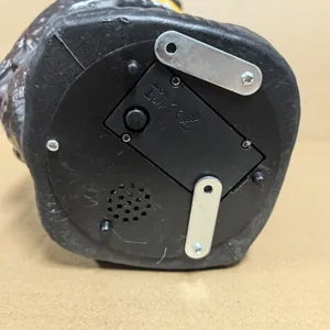 Detail view of the bottom power switch and speaker for the electronic owl garden ornament.