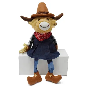 Detailed view of a cute cowboy highland cow plush toy sitting on a white block.