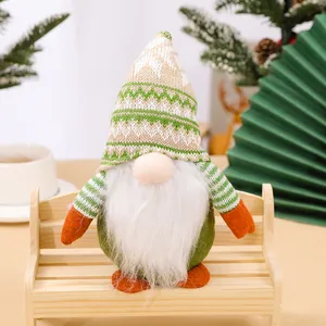 Festive knitted Christmas gnome doll with green hat and long white beard on a bench