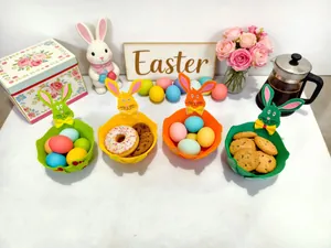 Bunte Filz-Osterhasenkörbe, gefüllt mit festlichen Leckereien und Eiern auf Tisch.