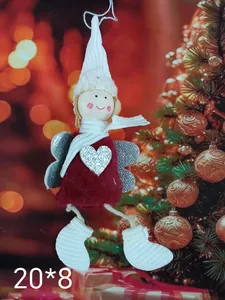 Close-up detail of plush Christmas angel ornament with red dress and silver heart