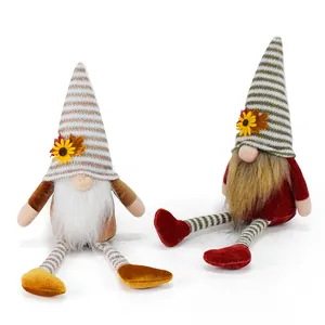 Detail of two handmade autumn faceless gnomes with striped hats and yellow sunflowers