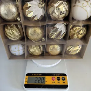 Set van 16 goud-witte kerstballen van 220g, getoond op een weegschaal voor de meting