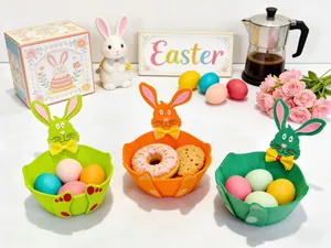 Drei bunte Osterkörbe aus Filz in Hasenform, gefüllt mit Eiern und Keksen in Festtagsstimmung